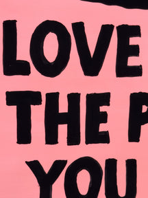 Close-up of bold black message lettering on the pink surface of LOVE EVEN THE PARTS YOU HIDE, TAROART by TAROUT 00031