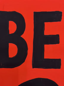 Close-up of the bold black BE lettering on the red surface of BE YOU!, TAROART by TAROUT 00033