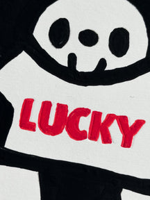 Close-up of LUNNY holding a white T-shirt reading LUCKY